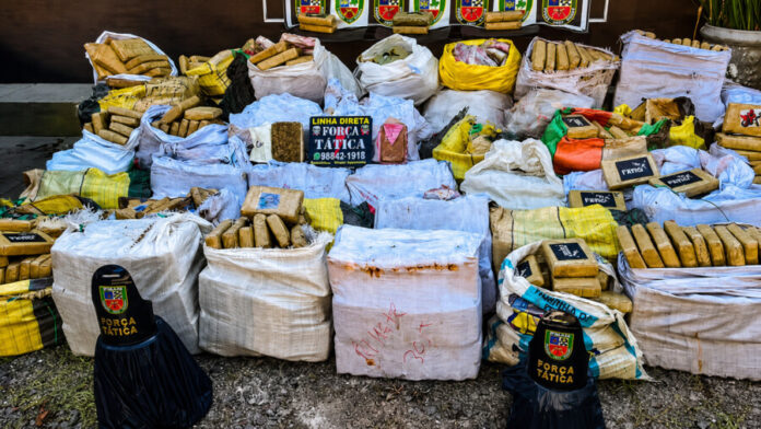 ALT da imagem: Drogas, coletes balísticos e veículo apreendidos durante operação da Força Tática em Manaus.